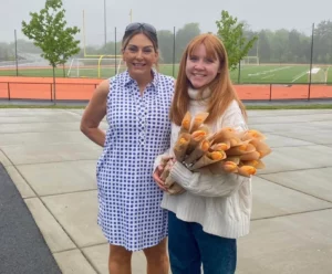 Catherine McGonagle, STEMS Co-Founder & President, holding orange tulips