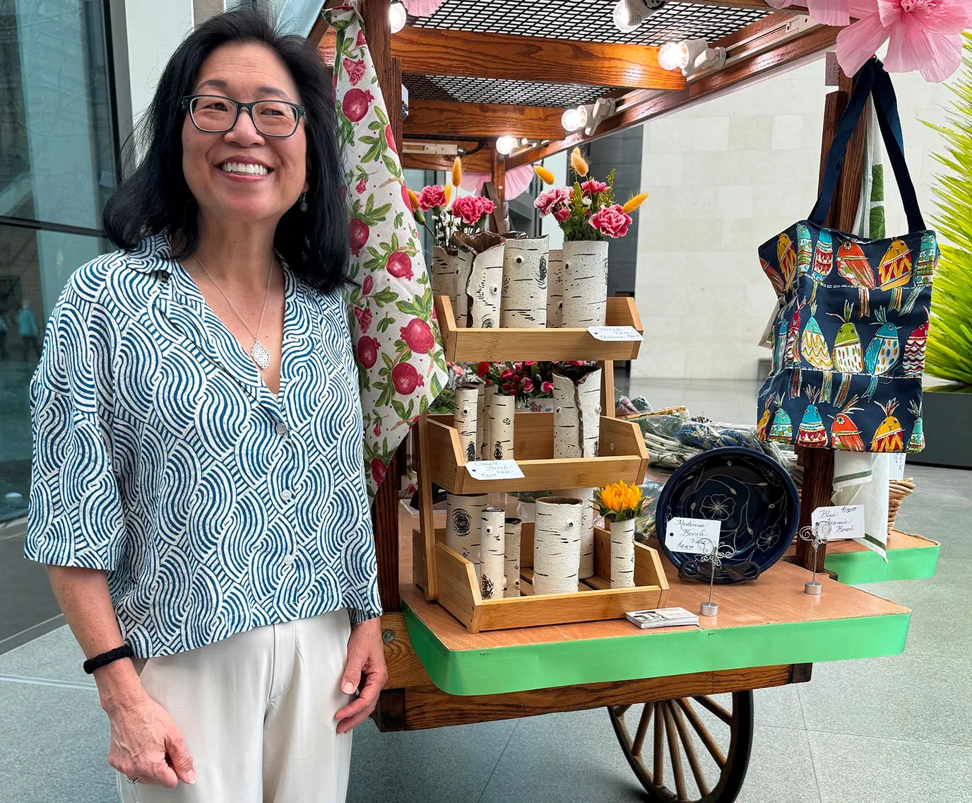 JC Donovan standing in front of a display that showcases her pottery.